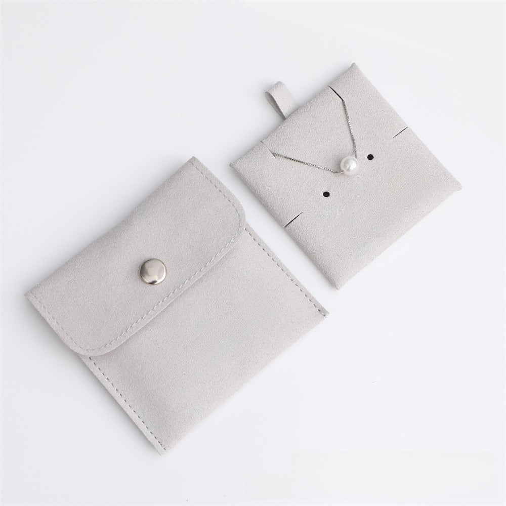 Two light gray fabric jewelry pouches on a white background