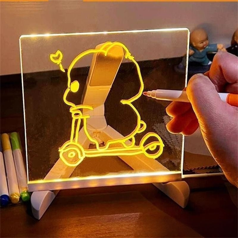 Hand holding a pen over a transparent board with a yellow scooter design, illuminated by LED lights.