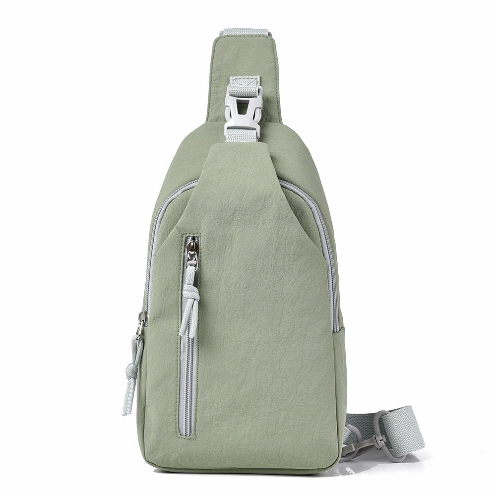 Green sling bag with zippers on a white background