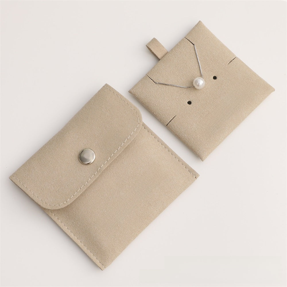 Beige jewelry pouch with a necklace on a white background
