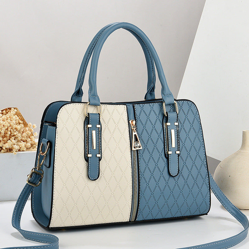 Blue and beige handbag with a strap on a light gray background