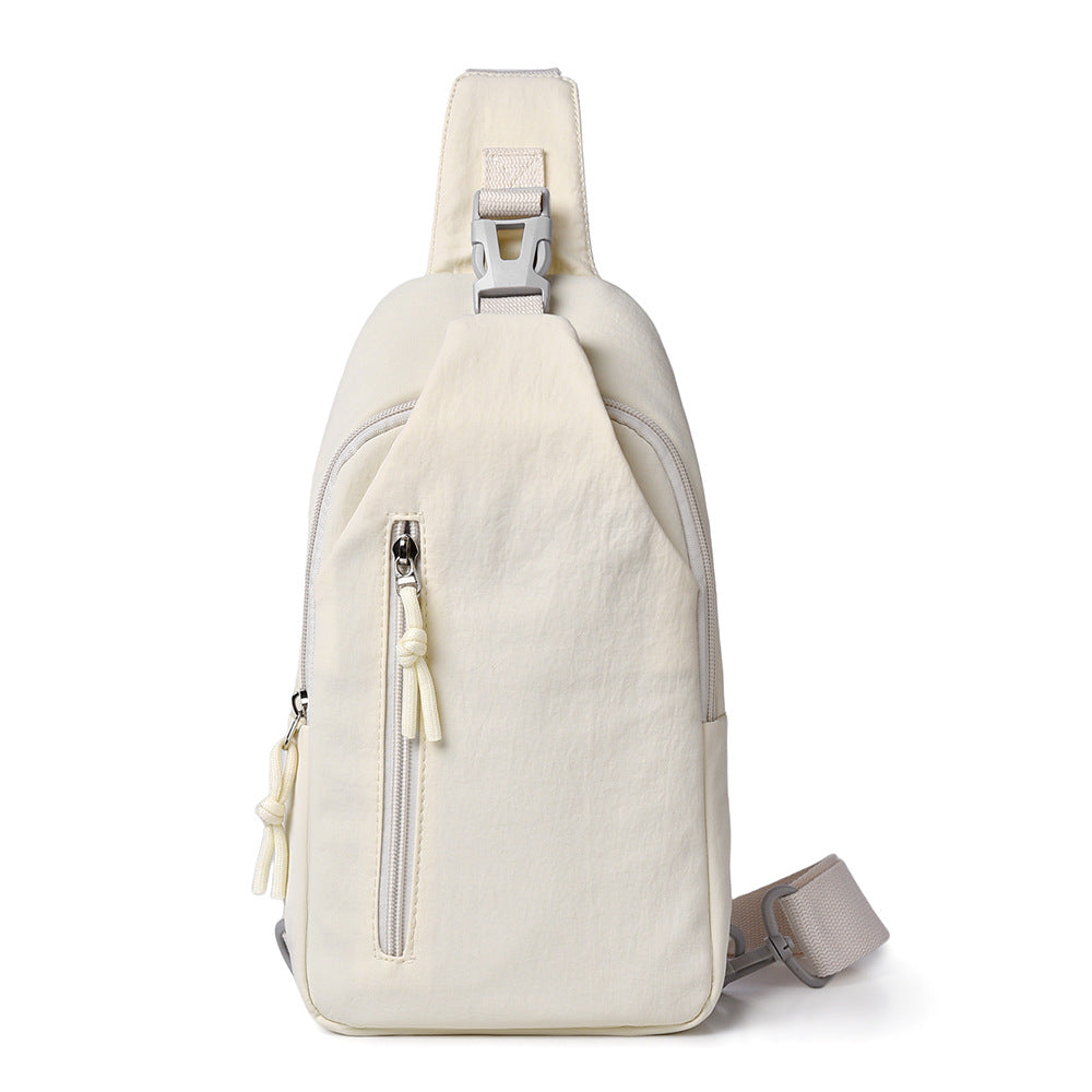 Beige sling bag with zippers on a white background