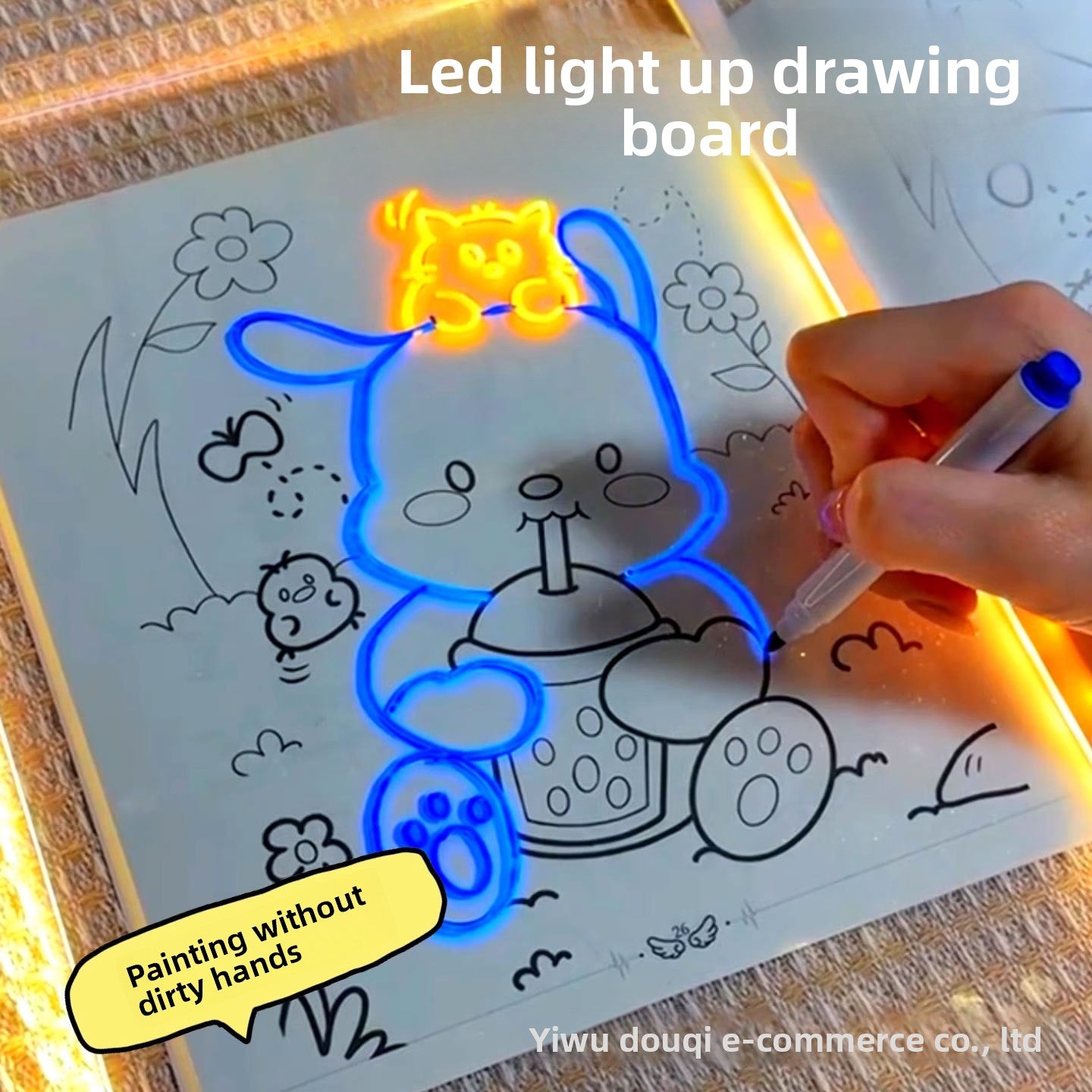 LED light-up drawing board with a hand drawing a blue cat character on a coloring book page.