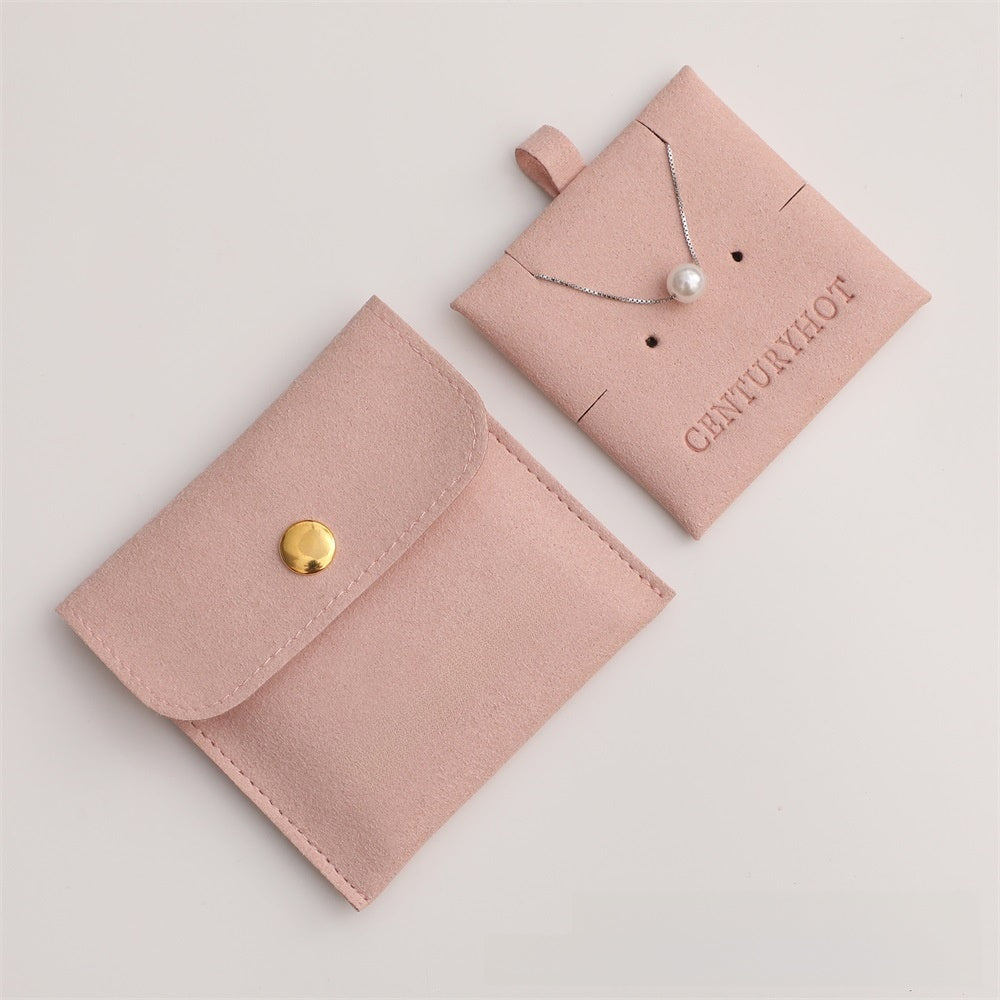 Pink jewelry pouch with a gold button and a necklace on a pink card with 'CENTURY' branding.