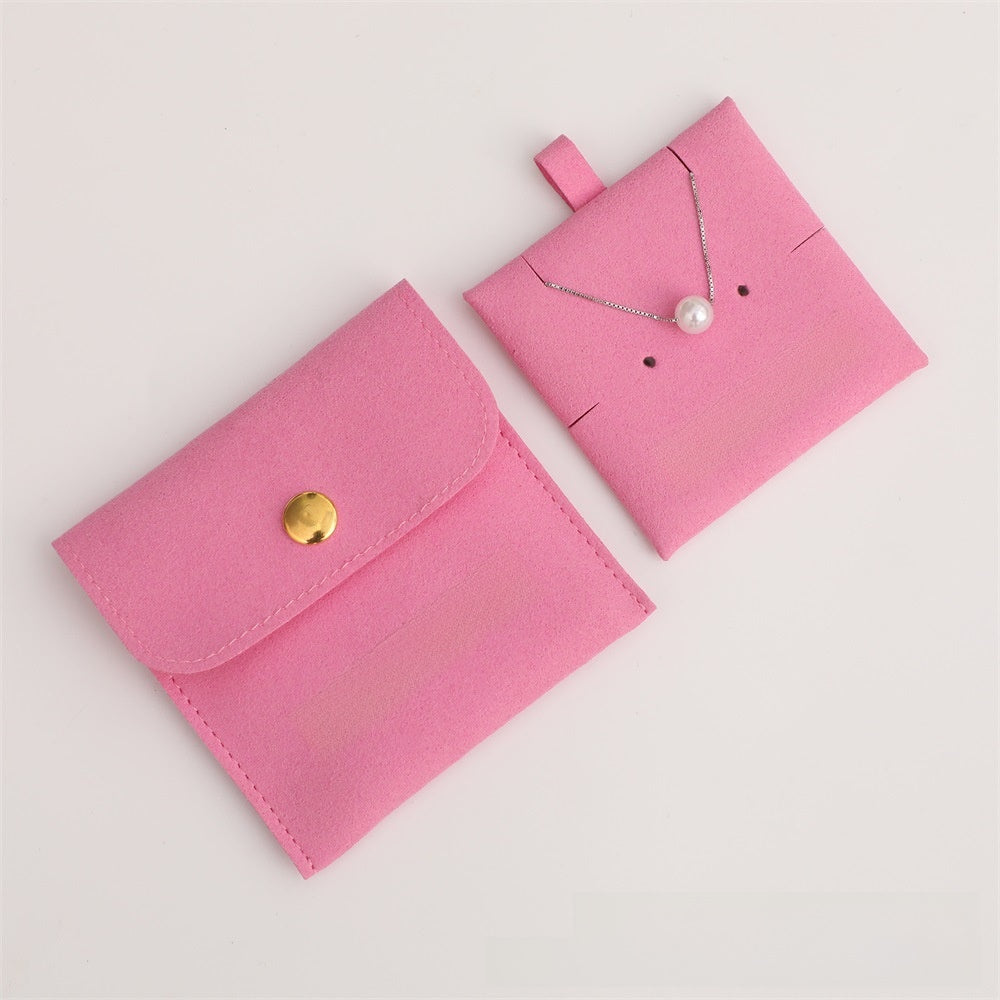 Two pink jewelry pouches with a necklace inside on a light gray background