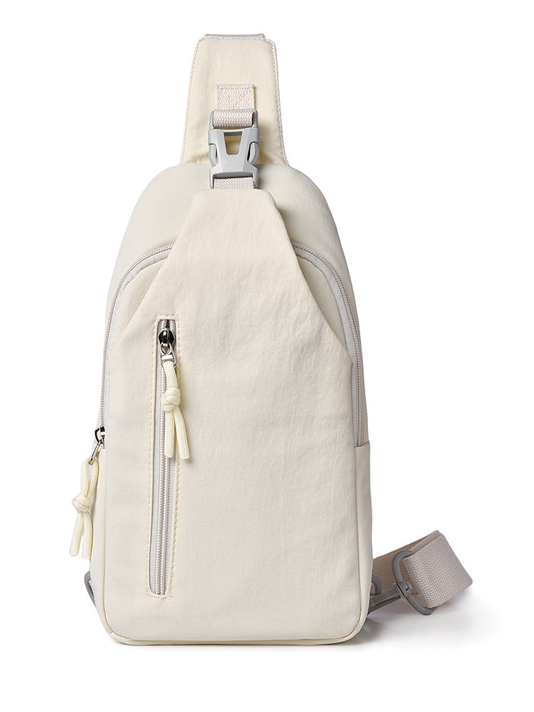 Beige sling bag with zippers on a white background