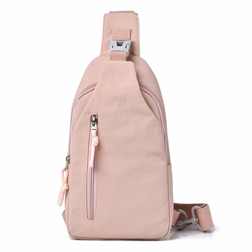 Pink sling bag with zippers on a white background
