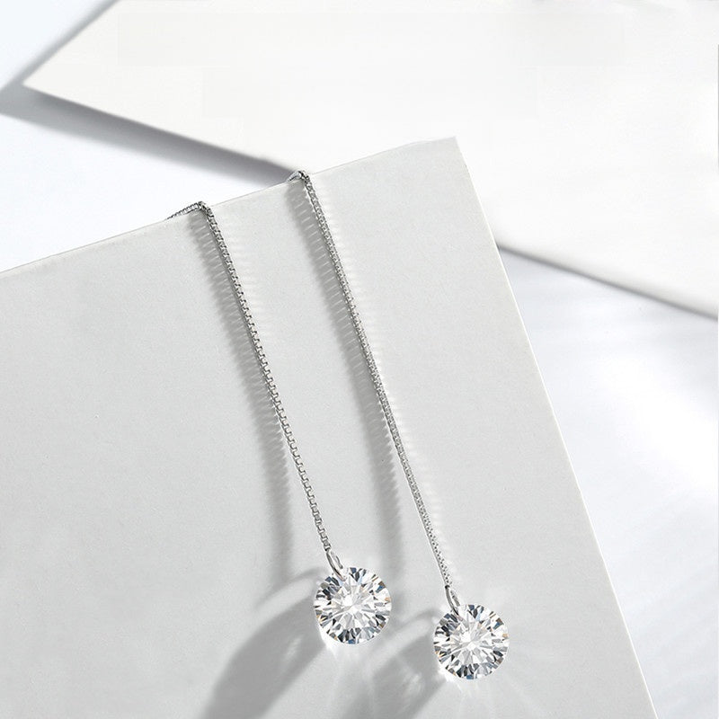 Silver necklace with round pendants on a light gray surface