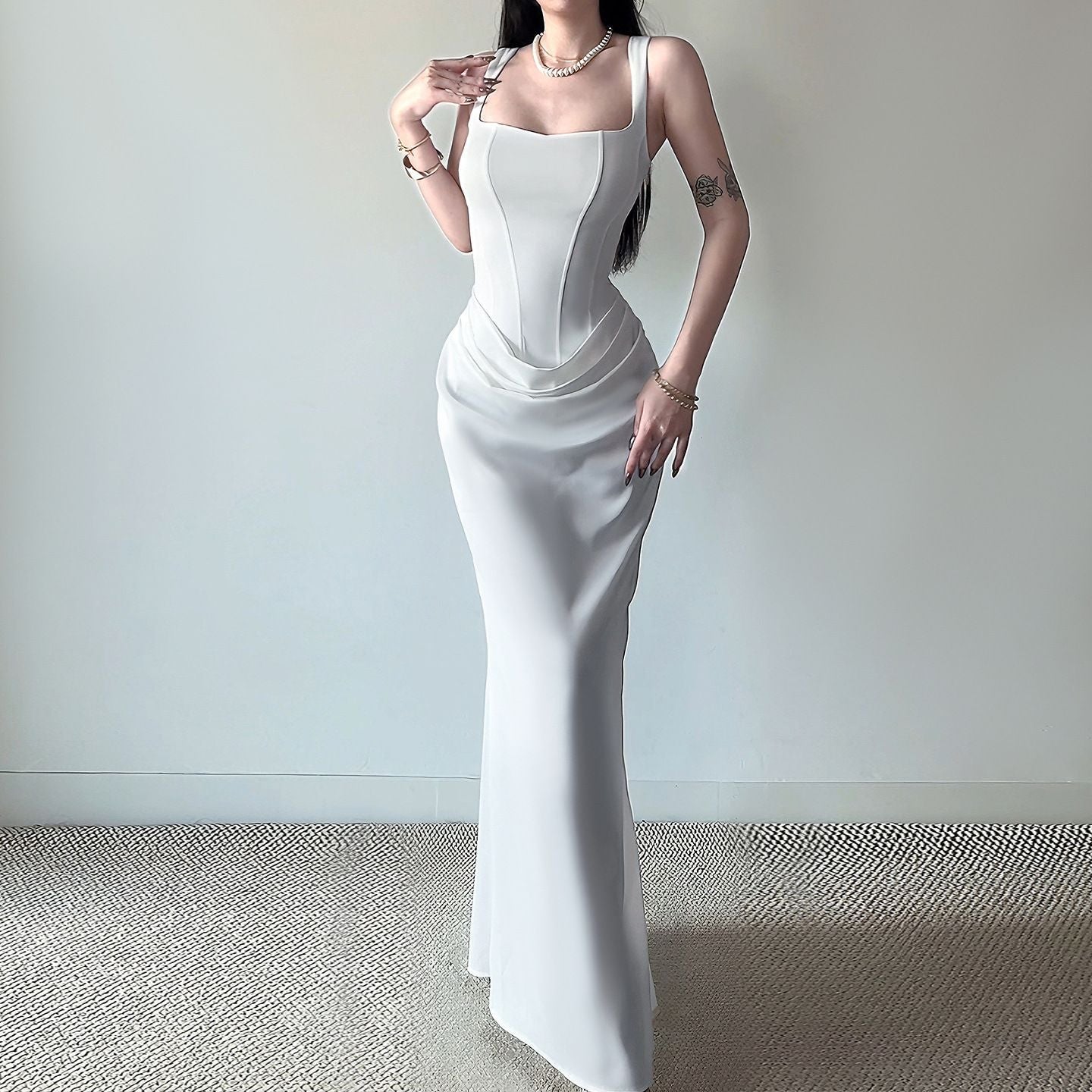 Woman wearing a white evening gown against a plain background