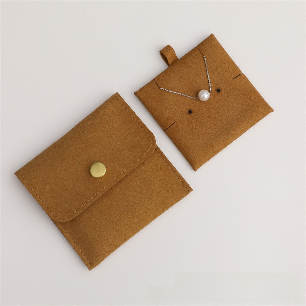 Brown jewelry pouch with a necklace on a light gray background