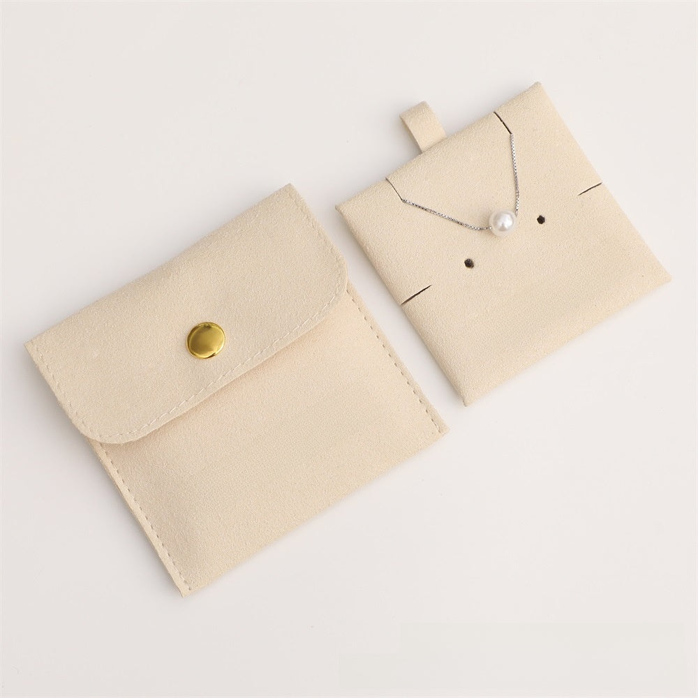Beige jewelry pouch with a necklace on a light gray background