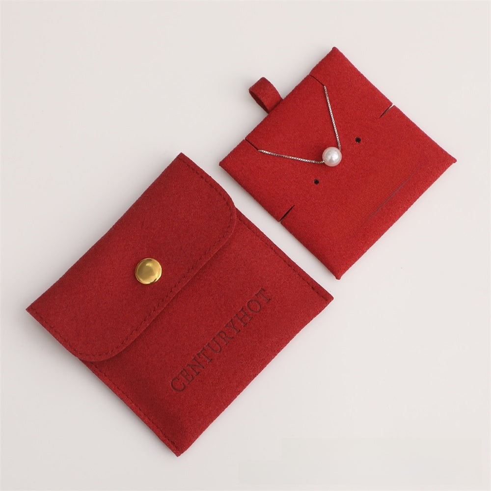 Red jewelry pouch with a pearl necklace on a light gray background