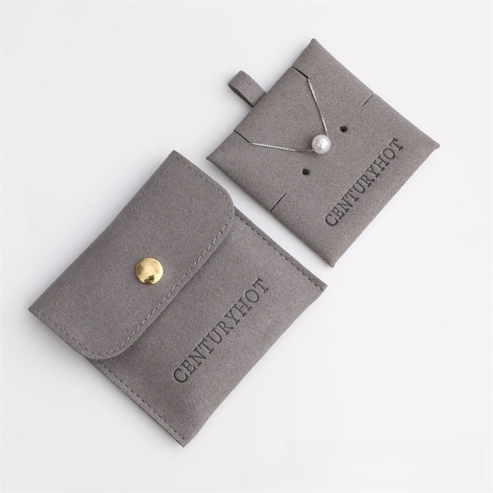 Gray jewelry pouch with a necklace on a white background